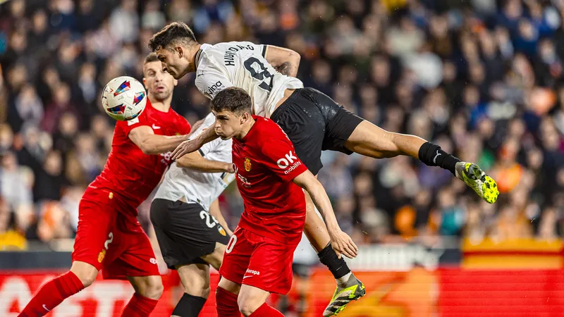 Cầu thủ của Valencia vượt qua hàng phòng ngự của Mallorca trong trận đấu bóng đá sôi động